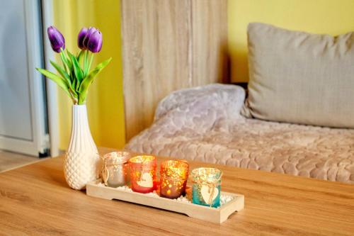 a table with a vase of purple flowers and candles at Apartments Stella in Virpazar