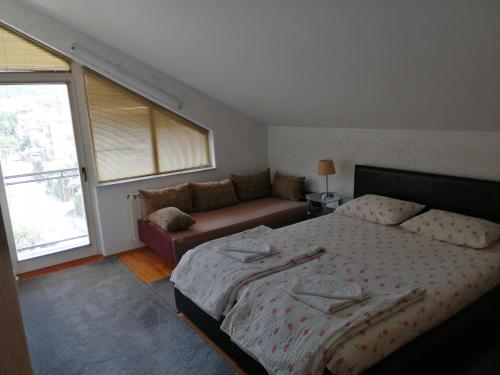 een slaapkamer met een bed en een bank bij Luxury Apartment Biljana in Ohrid