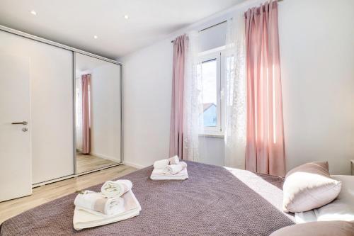 - une chambre avec un grand lit et des serviettes dans l'établissement Beautiful new apartment Blaz, à Mali Lošinj