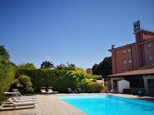 a swimming pool in front of a building at Albergo Zoello Je Suis in Castelvetro di Modena