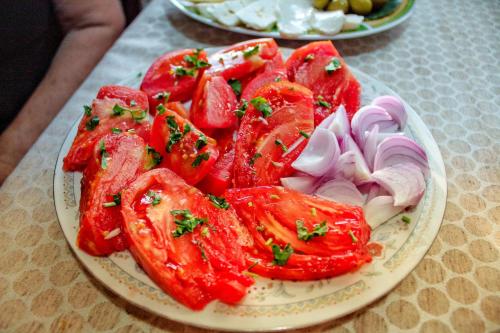 a plate of tomatoes and onions on a table at Apartments Stella in Virpazar