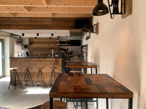 a dining room with wooden tables and a kitchen at La Faironnière in Hamoir
