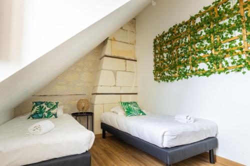 Cette chambre mansardée dispose de 2 lits et d'une peinture murale. dans l'établissement Taiiga - Domaine Tropical, à Saint-Aignan