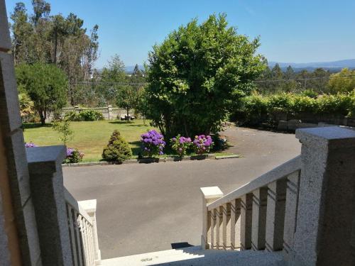 a view of a driveway with flowers in a yard at Apartamentos Turísticos San Breixo in Carballo