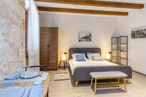 een slaapkamer met een kingsize bed en een tafel bij The 3 Figs in Poreč