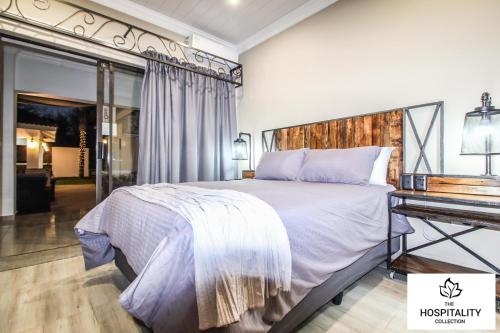 a bedroom with a large bed and a desk at 42 Upon Williams Guesthouse in Klerksdorp
