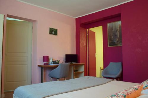 a bedroom with a bed and two chairs and a desk at Chambres d'Hôtes L'Orée des Bois in Lacrouzette