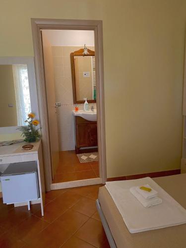 a bathroom with a mirror and a sink and a bed at Il Nido Delle Rondini in Grottole