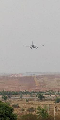 a plane flying in the sky over a field at Hotel Airport Residency Bangalore in Devanahalli-Bangalore