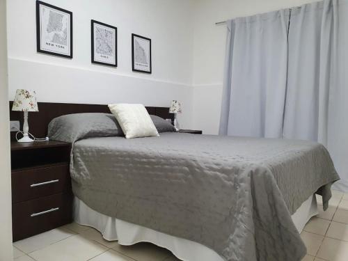 um quarto com uma cama e uma mesa de cabeceira com 2 candeeiros em Apart Ocampo Catamarca II em San Fernando del Valle de Catamarca