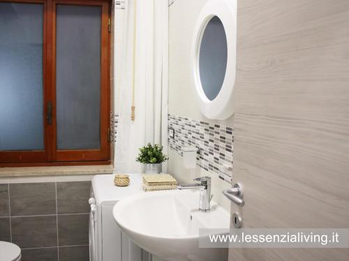 a bathroom with a sink and a mirror at L'ESSENZIAL LIVING in Messina