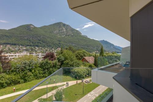 a glass balcony with mountains in the background at Rivage Hôtel & Spa Annecy in Annecy
