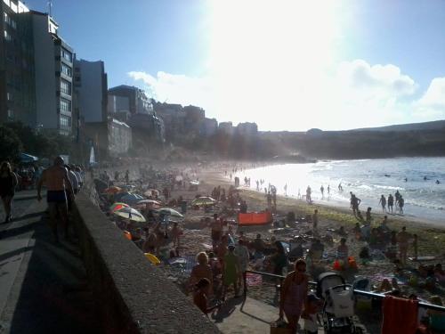 a crowd of people on a beach near the ocean at Apartamentos Turísticos San Breixo in Carballo