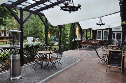 an outdoor patio with tables and chairs and a sign at Savoy in Spała