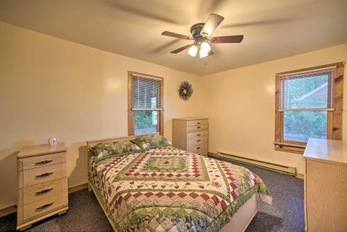 a bedroom with a bed and a ceiling fan at Riverfront Escape with Dock 19 Mi to Saratoga! in Lake Luzerne