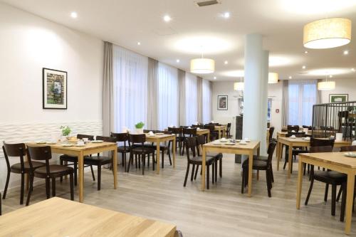 ein Esszimmer mit Holztischen und -stühlen in der Unterkunft Businesshotel Berlin in Berlin