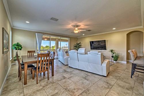 a living room with white furniture and a table at Bright Bayfront Home Less Than 2 Mi to Hernando Beach! in Hernando Beach