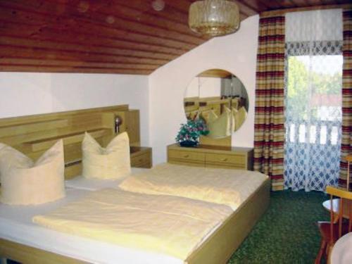 a bedroom with a large bed and a mirror at Ferienwohnung Knittler in Waging am See