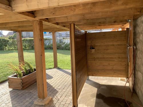 a wooden pergola with a shower in a yard at La Villa L'Escale in Audresselles