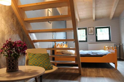 a loft bed in a room with a bed and a table at Ferienhaus an der Salzkirche in Tangermünde