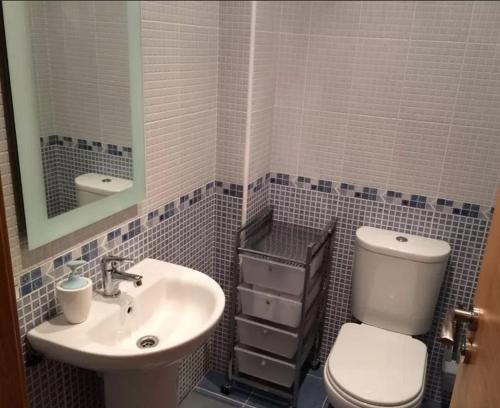 y baño con aseo blanco y lavamanos. en Apartment - 2 Bedrooms - 02447, en Malpica de Bergantiños