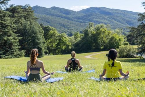 three women sitting in a field doing yoga at Domaine Les Sources de Dieulefit in Dieulefit