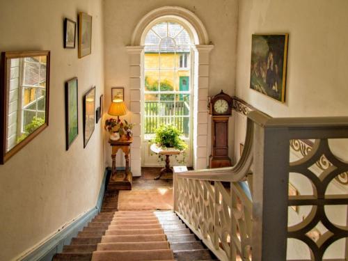 a staircase in a home with a window and a clock at Roundwood House in Mountrath