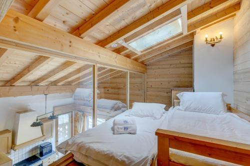 a bedroom with two beds in a wooden house at Rose et Chardon Apartment - Snow and Trek - Morzine in Morzine