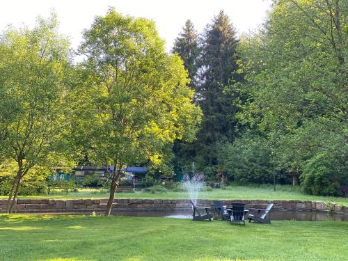 a fountain in a park with a table and chairs at Thalhauser Mühle Hotel-Restaurant in Thalhausen
