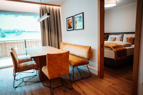 a room with a table and chairs and a bed at Carpe Solem Rauris by ALPS RESORTS in Rauris