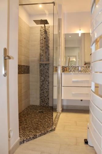 une douche avec une porte vitrée dans une salle de bain dans l'établissement Les Baux 1, à Sanary-sur-Mer