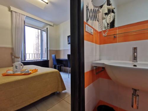 a bathroom with a bed and a sink in a room at Mocenigo Vatican Suites in Rome