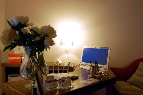 a desk with a laptop computer and flowers on it at PortAtenea - Atenea Collection in Agrigento