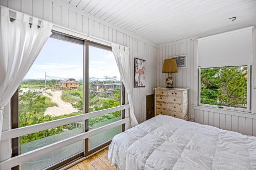 ein Schlafzimmer mit einem Bett und einem großen Fenster in der Unterkunft Robbins Rest Retreat in Ocean Beach