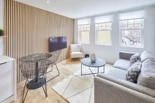 a living room with a couch and a table and a tv at Host & Stay - Golden Lion Apartments in Whitby