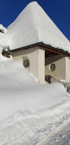 a snow covered building with a pile of snow at Haus Anna Ein Haus mit Herz in Fliess