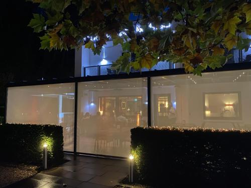 a house with glass windows at night with lights at Thalhauser Mühle Hotel-Restaurant in Thalhausen