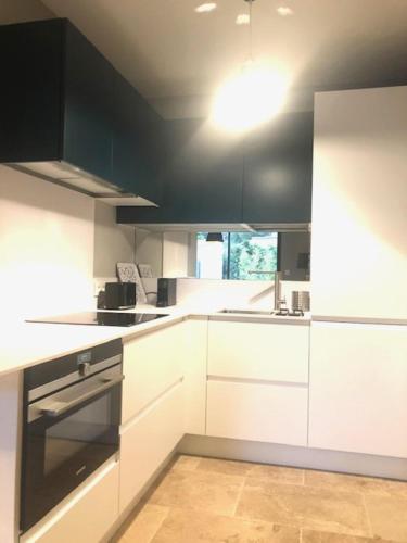 une cuisine avec des armoires blanches et un four à plaques de cuisson dans l'établissement L'ete Indien 1, à Sanary-sur-Mer