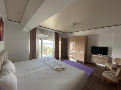 a bedroom with a large white bed and a television at White Tower Mamaia Prestige Apartments in Mamaia