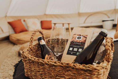 a basket filled with wine bottles and a book at Cocooning Tipi - Seignosse in Seignosse