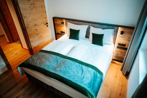 a bedroom with a large bed with green pillows at Carpe Solem Rauris by ALPS RESORTS in Rauris