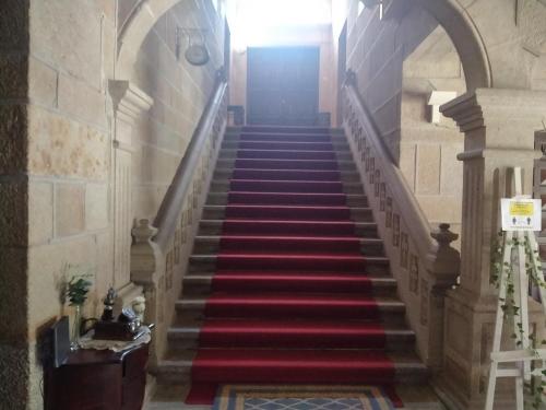 a staircase with red carpeted stairs in a building at Vilavella alojamiento de época in Redondela