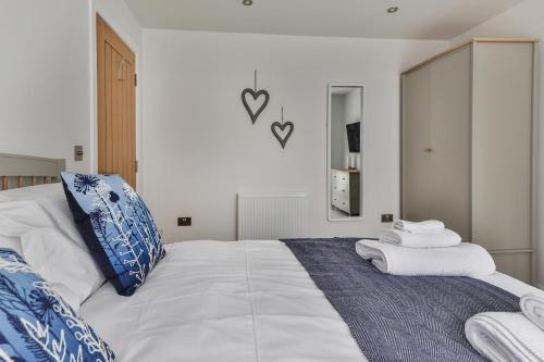 a bedroom with a large white bed with towels on it at Finest Retreats - 11 Belle House in Filey