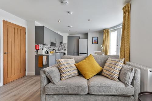 a living room with a couch and a kitchen at Finest Retreats - 13 Belle House - Apartment 1 in Filey