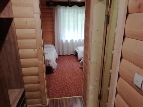 a small room with two beds and a window at Cheremosh in Yablunytsya