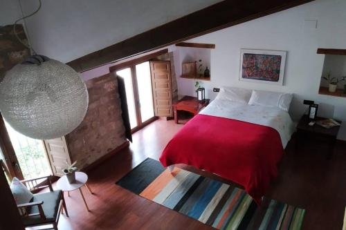 a bedroom with a large bed with a red blanket at Casa Cerros de Úbeda 1630 in Úbeda