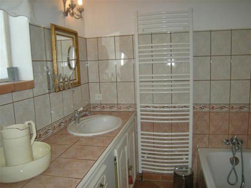 bagno con lavandino, vasca e specchio di CHAMBRE D'HÔTE LE GRAND BARSAN a Vaison-la-Romaine