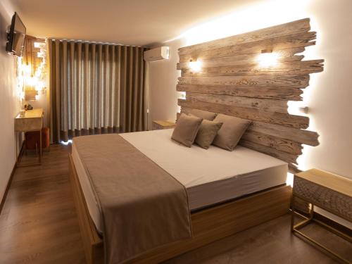 - une chambre avec un lit et un mur en bois dans l'établissement Golden Mirror, à Lamego