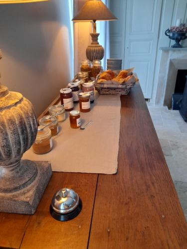 una mesa con tarros de mermelada y pan. en LE CLOS DE L AGNEAU, en Saint-Amand-sur-Fion
