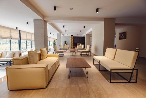 a lobby with couches and chairs and a table at Crystal Hotel & SPA in Bakuriani